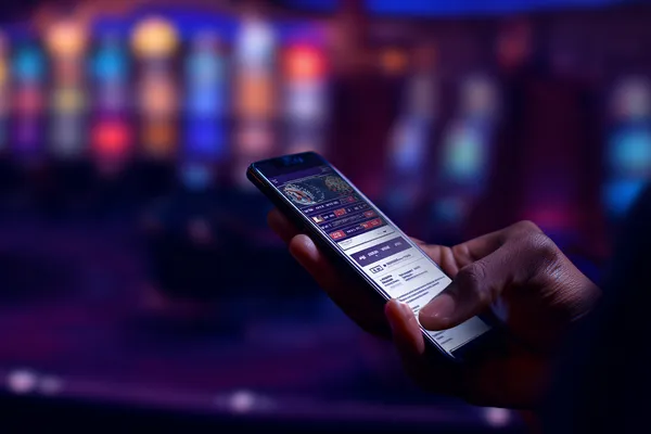 JETA90 Mobile App — Your complete hub for casino and sports A man focused on his laptop with live stats in the background, highlighting the dedicated sports and gaming features of the JETA90 mobile app.