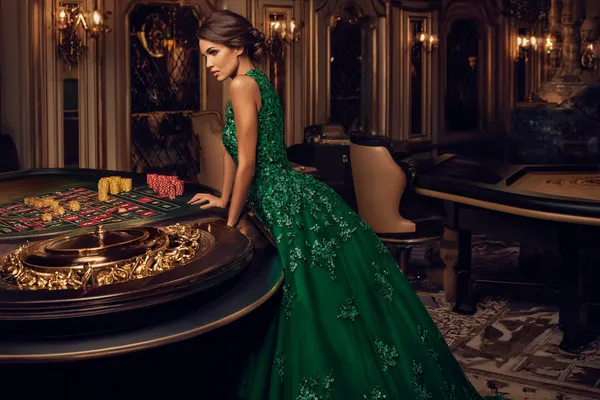 JETA90 — A high-class gaming experience without limits A woman in a luxurious green gown next to an ornate roulette wheel, capturing the upscale casino mood of JETA90.